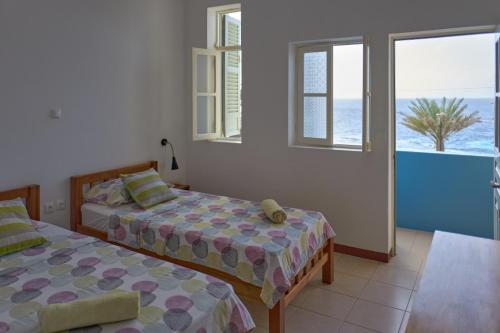 een slaapkamer met 2 bedden en uitzicht op de oceaan bij Música do Mar in Ponta do Sol