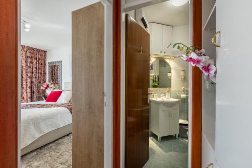 1 dormitorio con 1 cama y baño con lavamanos en Apartment Desert Rose, en Split