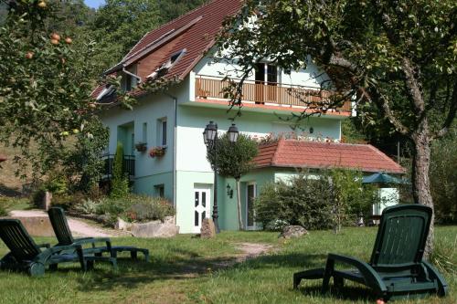una casa con dos sillas de jardín delante en Les Gites La Cerisaie, en Breitenbach