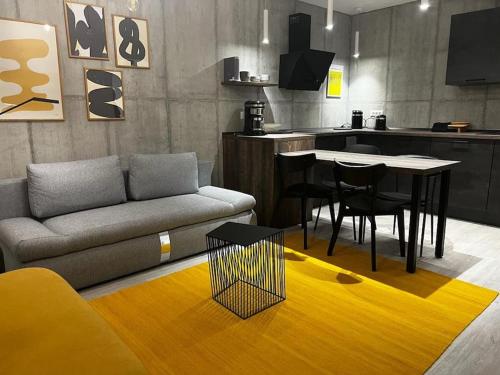 a living room with a couch and a table and a kitchen at Downtown Chic 2 in Iaşi