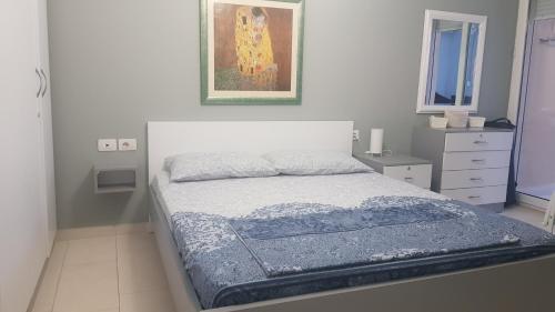 a bedroom with a bed and a painting on the wall at Apartment bay, Bougainville Bay Resort in Sarandë