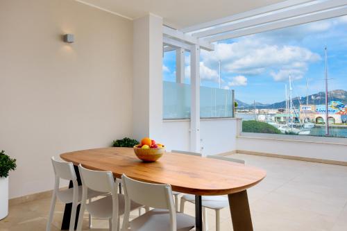 a wooden table and chairs in a room with a window at Olbia Luxury Apartment in Olbia