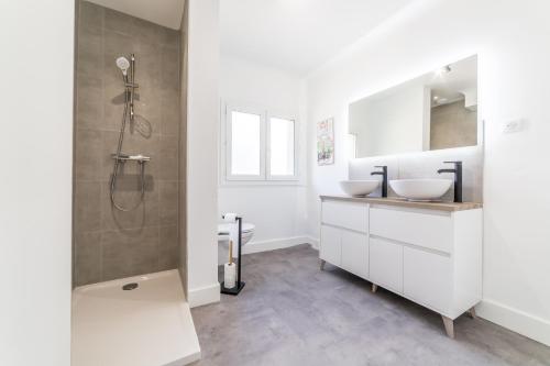 ein weißes Bad mit 2 Waschbecken und einer Dusche in der Unterkunft @Villa au coeur de Brive@ avec jardin et garage in Brive-la-Gaillarde
