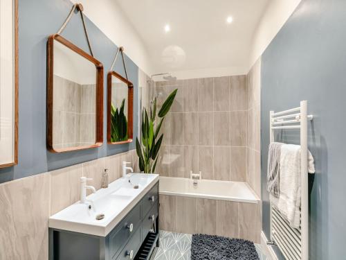 a bathroom with a tub and a sink and mirror at Verona House in Tideswell