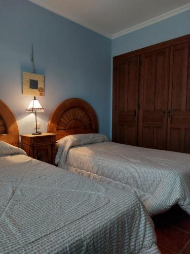 カンデレダにあるLos 11 Postesのベッドルーム1室(ベッド2台、ランプ付きテーブル付)