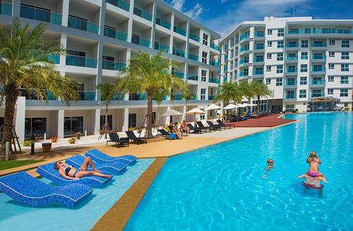 Mae Phim Grand Blue Condo 508 with pool and seaview في ماي بيم: مسبح الفندق مع وجود ناس في الماء