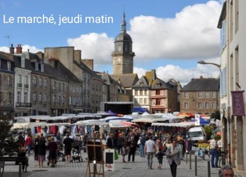 a group of people walking around a market in a city at Perle rare, appartement paisible et cosy in Lamballe
