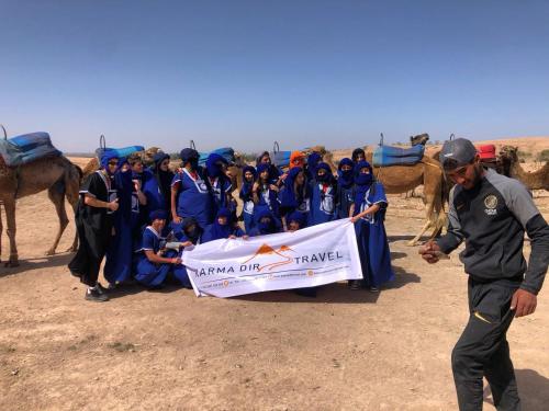 a man holding a banner in front of a group of people at Hotel Medina in Marrakesh