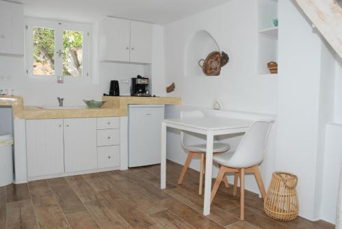 Livadi Astypalaias的住宿－Siesta Villas nearby Tzanaki Beach Livadi，白色的厨房配有白色的桌子和椅子