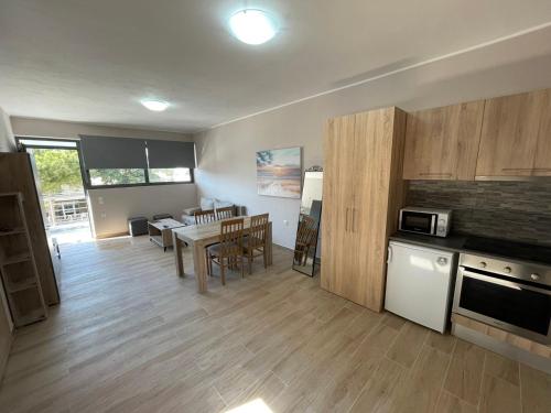 a kitchen and living room with a table and a dining room at AVR Airport Deluxe Suites 6 AIRPORT FREE SHUTLE in Markopoulo