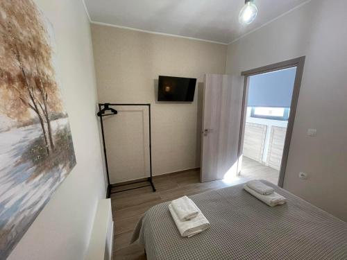 a bedroom with a bed and a television on a wall at AVR Airport Deluxe Suites 6 in Markopoulo