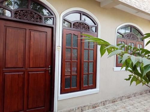 un par de puertas rojas en una casa en Shalona Holiday Home en Galle