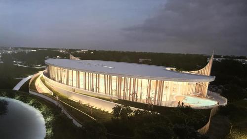 un bâtiment avec une façade éclairée à côté d'un lac dans l'établissement Joli studio spacieux au rez de chaussée, à Denain