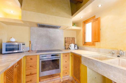 a kitchen with a sink and a microwave at YourHouse Son Jaumell in Capdepera