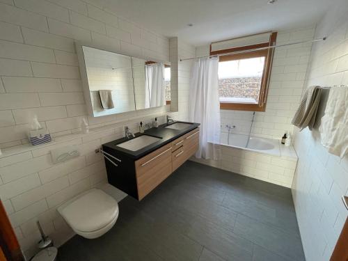 a bathroom with a sink and a toilet and a tub at Wunderschönes Gästehaus mit grandioser Aussicht in Gempen