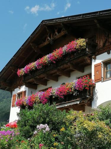 a building with flowers on the side of it at Schottenhof in Fulpmes