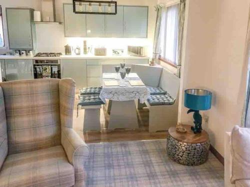a living room with a table and a kitchen at Willow Lodge , Corskie Drive Macduff-Banff in Macduff