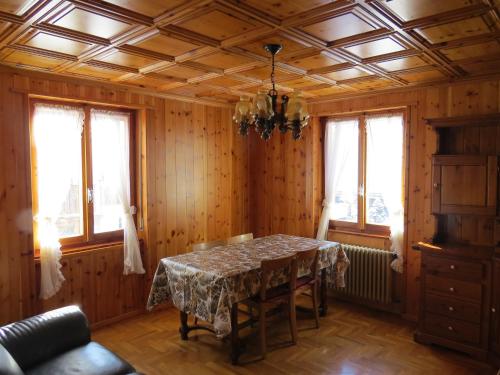 een eetkamer met een tafel en een aantal ramen bij Stüa Valfurva in Valfurva