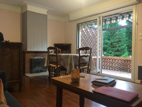 un salon avec une table et une cheminée dans l'établissement Logis Letellier, à Salies-de-Béarn