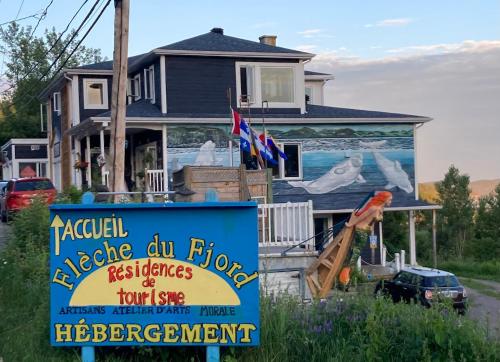 une maison avec un panneau devant elle dans l'établissement Suite 2, Flèche du fjord, vue Saguenay, Mont Valin, à Saint-Fulgence