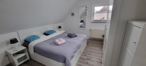 Un dormitorio con una cama con una bolsa rosa. en Haus am Meer, en Schweiburg