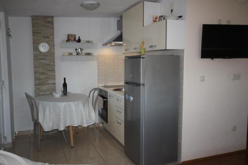 a small kitchen with a table and a refrigerator at Apartmani Marijana in Lozovac