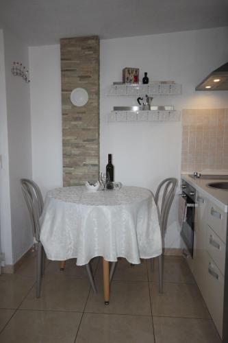 a table with a white table cloth on it in a kitchen at Apartmani Marijana in Lozovac