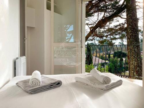 - un lit blanc avec des serviettes et une fenêtre dans l'établissement Appartement Marine, à Soorts-Hossegor