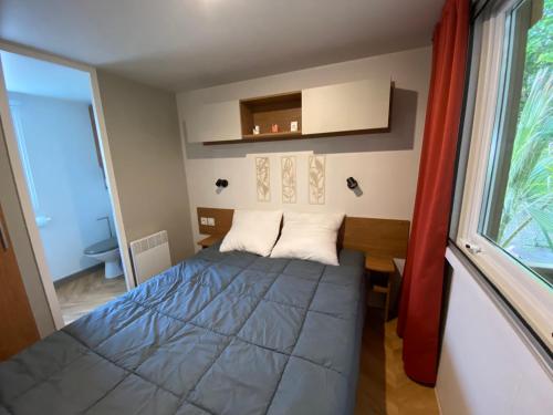 a small bedroom with a bed and a window at Neuf 2022, 6-8 personnes, piscine, vacancesdenani in Saint-Julien-en-Born