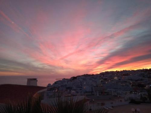 a view of a city with a sunset at douceur d'algarve in Albufeira
