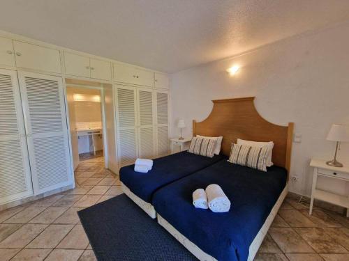 a bedroom with a blue bed with two white pillows at douceur d'algarve in Albufeira