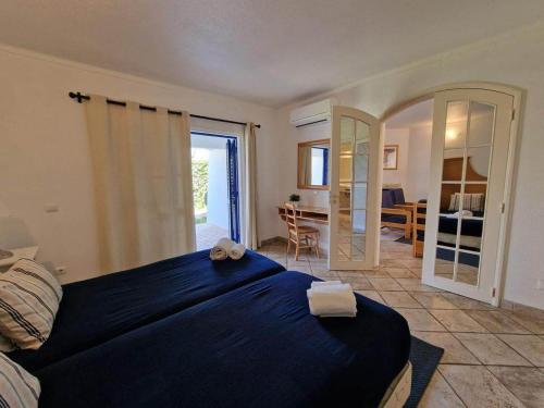 a bedroom with a blue bed and a living room at douceur d'algarve in Albufeira