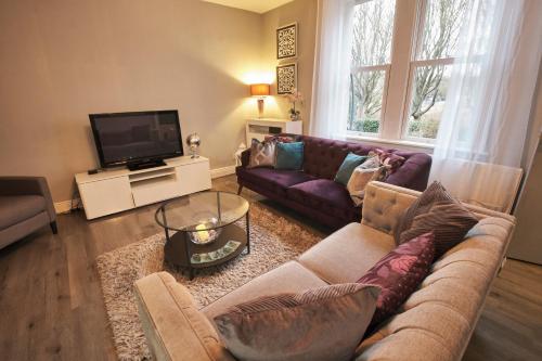 a living room with a couch and a tv at Your Home from Home - River bank in Cox Green