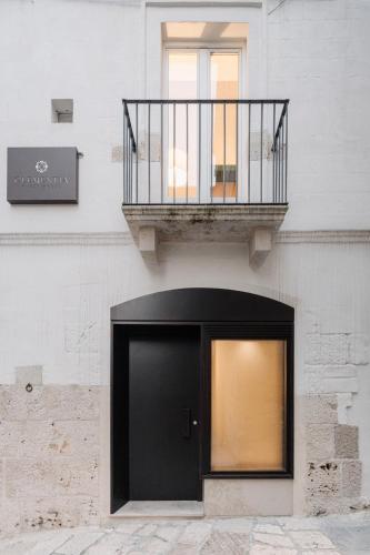 a building with a black door and a balcony at Clementia Guest House in Altamura