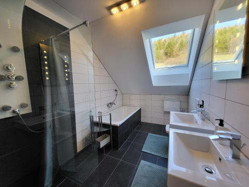 uma casa de banho com uma banheira, um lavatório e um chuveiro em Ferienwohnung Zartgrün Blumberg em Blumberg