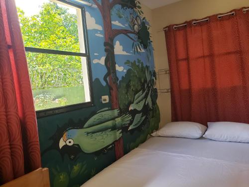 a bedroom with a painting of a bird on the wall at Casa Mokoron in Managua