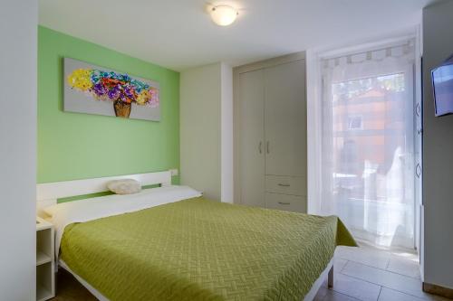 1 dormitorio con 1 cama y una pintura en la pared en Lotta, en Nerezine