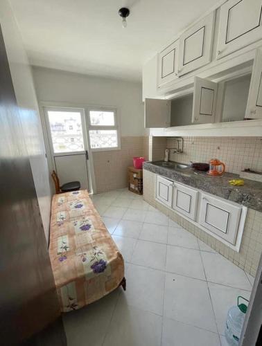 a kitchen with a bed in the middle of a room at Appartement in Oulad Yakoub