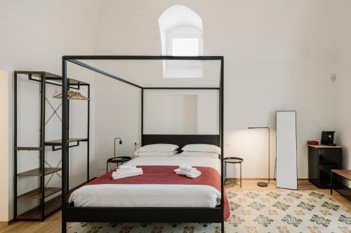 a bedroom with a canopy bed with a red blanket at Clementia Guest House in Altamura