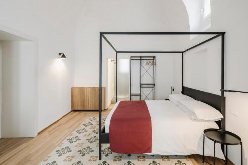 a bedroom with a canopy bed and a rug at Clementia Guest House in Altamura