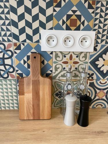 une table avec une planche à découper et des bouteilles sur un mur dans l'établissement APPART Le BER'AMAR L'ESTAQUE, à Marseille