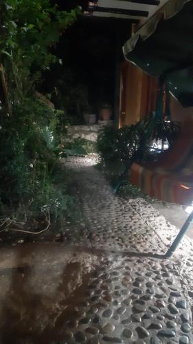 a cobblestone walkway at night with a table and plants at Wayras Hostal in Ollantaytambo