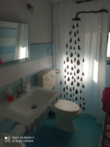 a bathroom with a toilet and a shower curtain at Villa Amenta in Fontane Bianche