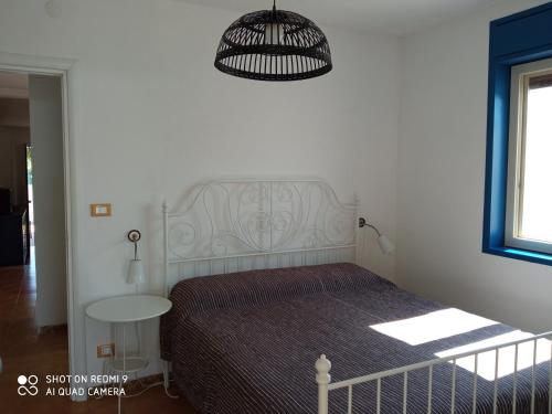 a bedroom with a bed and a table and a lamp at Villa Amenta in Fontane Bianche