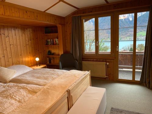 a bedroom with a bed and a large window at Chalet Rosemarie in Ringgenberg