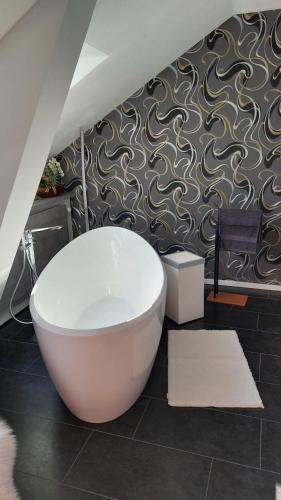 a bathroom with a large white bath tub on a wall at Suite Stuermer in Nordhausen