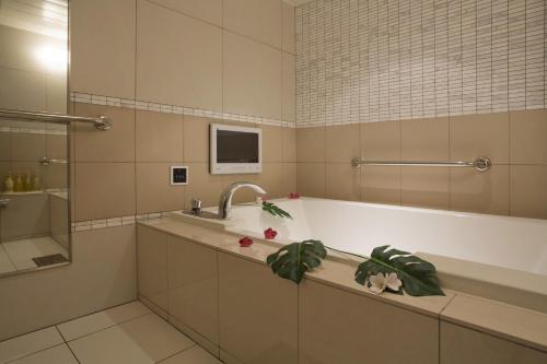 a bathroom with a bath tub and a sink at Hotel and Spa Lotus Modern (Adult Only) in Kyoto