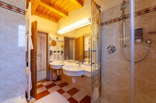 a bathroom with two sinks and a shower at Taushof in Schenna