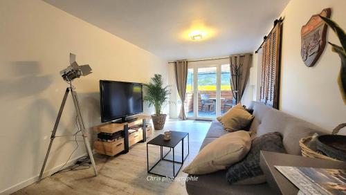 a living room with a couch and a television at Entre Ciel et Verdon in Castellane