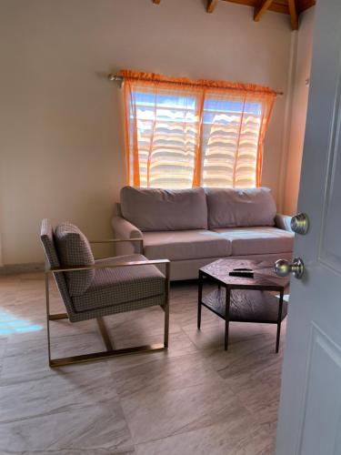 a living room with a couch and a table at Poinciana Apartments - Holiday Rental in Woods